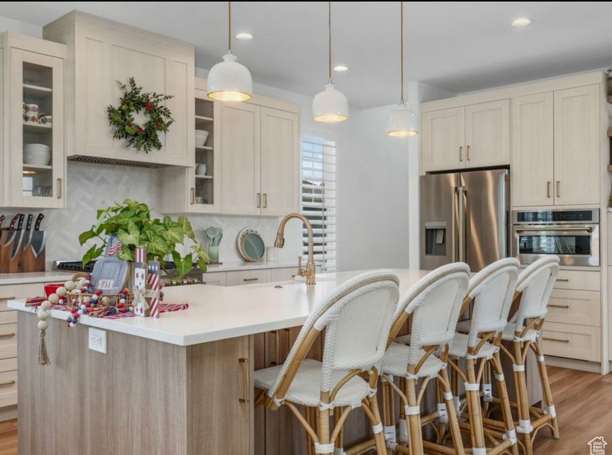 Bright white kitchen with gold pendant lights
